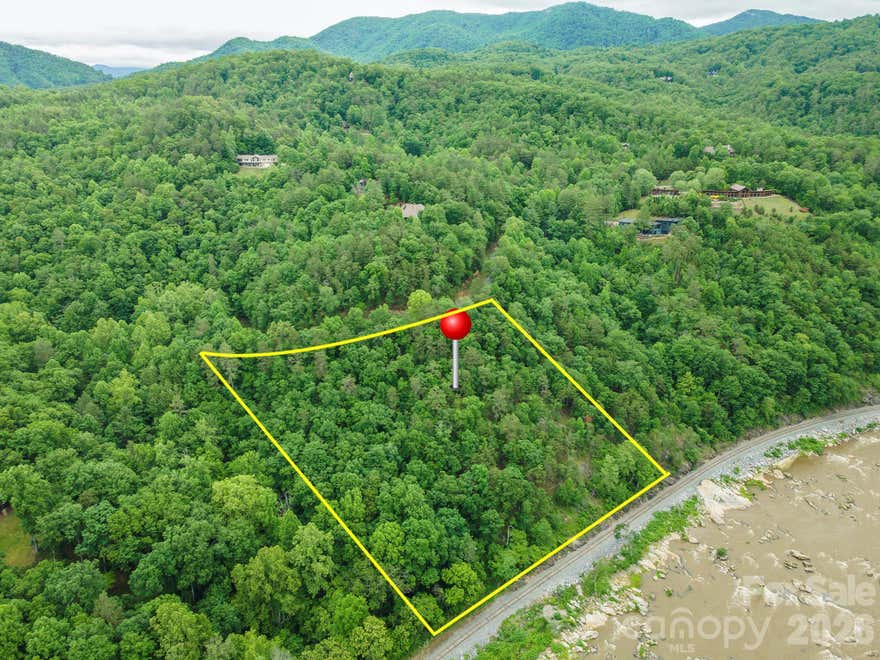 Welcome to 2391 French Broad Parkway, a stunning mountain retreat nestled within the gated riverfront community of French Broad Crossing in Marshall. Surrounded by breathtaking mountain vistas, protected forestland, and the scenic French Broad River, this property offers the perfect blend of privacy, natural beauty, and resort-style living.

Located in one of Western North Carolina's premier conservation communities, homeowners enjoy access to an exceptional collection of amenities designed for both adventure and relaxation. Gather with neighbors at the timber-frame River Lodge overlooking the river, stay active in the Wellness Center and fitness facility, or unwind at the community pool and hot tub. Outdoor enthusiasts will appreciate miles of hiking, biking, and UTV trails, river access for kayaking, canoeing, tubing, and fishing, as well as the Riverfront Family Park and Pavilion for picnics and gatherings. Residents also enjoy community fire pits, scenic overlooks, and more than 230 acres of permanently protected conservation land woven throughout the neighborhood.

Just 30 minutes from Asheville and minutes from Marshall, Hot Springs, and the Blue Ridge Parkway, French Broad Crossing offers the rare opportunity to enjoy a peaceful mountain lifestyle without sacrificing convenience. Whether you're seeking a full-time residence, mountain getaway, or legacy property to share with future generations, 2391 French Broad Parkway delivers an extraordinary opportunity to experience the best of Western North Carolina living.