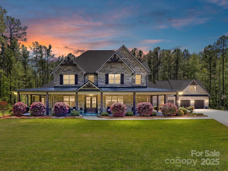 Exquisite Cabarrus County estate on 6.28 serene acres with no HOA. Built in 2018, this custom-designed residence offers refined living with 5 beds, 5.5 baths, white oak floors, and a chef’s kitchen featuring a quartz island and professional-grade range. Enjoy a private wine cellar, home office, and a luxurious primary suite with dual vanities, soaking tub, walk-in shower, and fitness room. A second main-level ensuite adds convenience with three large rooms, all with private bathrooms!. Outdoor living is elevated with a wrap-around porch, screened veranda with stone fireplace and infrared heater, patio, BBQ area, hot tub, and gazebo. A detached 3-car garage includes a spacious loft with full bath and kitchenette—ideal for guests or studio space. Ample room for a pool or additional buildings. This is luxury country living at its finest!