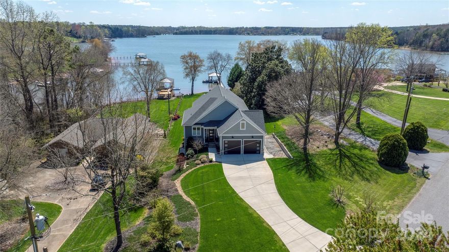 This stunning property boasts elegance and sophistication. This exquisite home features unparalleled craftsmanship & attention to detail. Thoughtful design details, and strategically placed windows bring in light & capture the amazing views. The foyer welcomes you into a spacious & beautifully appointed living area w/ soaring ceilings, designer finishes, exposed brick & antique treasures. The kitchen is a chef's dream, w/ stainless steel appliances, custom cabinetry, and a large center island with an antique printer's table and an inlaid soapstone top. The luxurious primary suite offers a private retreat w/ a spa-like ensuite bathroom and expansive walk-in closet. The basement features a 2nd Family room, storage area & workshop. The outdoor living spaces include a covered deck & lower patio, creating the perfect setting for alfresco dining. The meticulously landscaped grounds showcase a hardscaped firepit area, and private dock, perfect for enjoying lake living with friends and family.