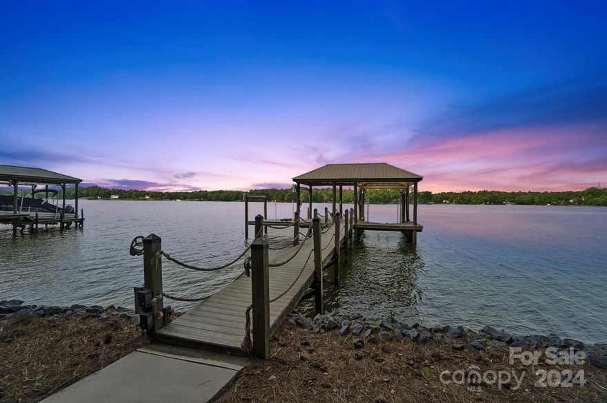 Welcome to luxury waterfront living at its finest in the prestigious River Hills, a gated golf and country club community on Lake Wylie! This magnificent estate boasts breathtaking views of open water to enjoy year-round with stunning sunset views. With 4 bedrooms and 4.5 bathrooms, this residence offers ample space for relaxation and entertainment. Picture yourself whipping up gourmet meals in the spacious kitchen, then gathering in the oversized two-story living room for cozy evenings with loved ones, all with picturesque views of the lake! All bathrooms have been updated and the elevator makes navigating this expansive home a breeze. Step outside to enjoy outdoor entertaining on the expansive deck or take a short stroll down the sidewalk to your private covered dock, complete with TWO lifts for your watercraft! With open water views, every day feels like a vacation! Don't miss out on the chance to experience lakeside living at its finest! (Some photos are virtually staged)