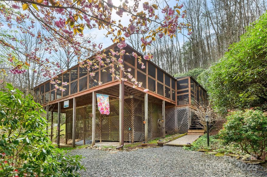 Located just outside of Leicester, in the popular Spring Creek Community, this mountain cabin's location is the perfect balance between country living, privacy, and access. Here you can relax on the wrap around porch while breathing in fresh mountain air. You'll enjoy easy, one level living from this low maintenance property. Watch in delight from just outside the glass lined, tree house like atmosphere of your living room as a fresh water spring trickles over natural rocks. Summertime is cool & green at 3600 ft above sea level! What a great escape from the heat this would be as a second home! Be sure to pick a pear from the abundant branches of the mature pear trees. Soon, as Fall gets in full swing, the property will show off with a blaze of color. Winter is cozy as you warm from in front of the wood stove. Each season seems more delightful than the next as mountain life ebbs & flows from this private sanctuary. Things are just more special on the mountain, & this comfortable cabin is sure to inspire if you seek an easy to access, close to Asheville getaway!  Your biggest decision will be where to sit on the porch! Safely below the home, well out any flooding risk, you will find a always flowing stream beside your own private gazebo! Fiber internet will keep you connected. Short or long term rentals are a-ok!