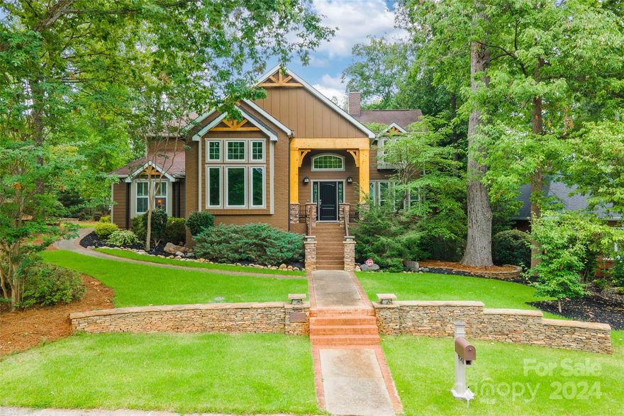 Nestled on a spacious wooded corner lot in the coveted Huntington Development, this gem offers an artists retreat that feels like a mountain getaway. Step in to discover hardwood floors that grace the main living areas, complemented by a kitchen that opens to a bright dining area & great room anchored by a brick gas log fireplace. Entertain with flex space, complete w/wet bar, wine cooler & ice maker. A slate-floored sunroom bathed in natural light beckons. Primary suite indulges w/an ensuite bathroom featuring spacious walk-in closet with walnut built-ins throughout, dual vanity, jetted bathtub & separate shower w/dual heads (1 rainfall) 4 jets plus a handheld & stained glass. A 2nd fireplace invites gatherings in the bonus room. Exquisite details include coffered & vaulted ceilings w/built-ins throughout. Climate-controlled storage areas add convenience. Can easily be converted to 5 BR. Outside, a large new deck awaits. This is a meticulously cared for home with attention to detail.