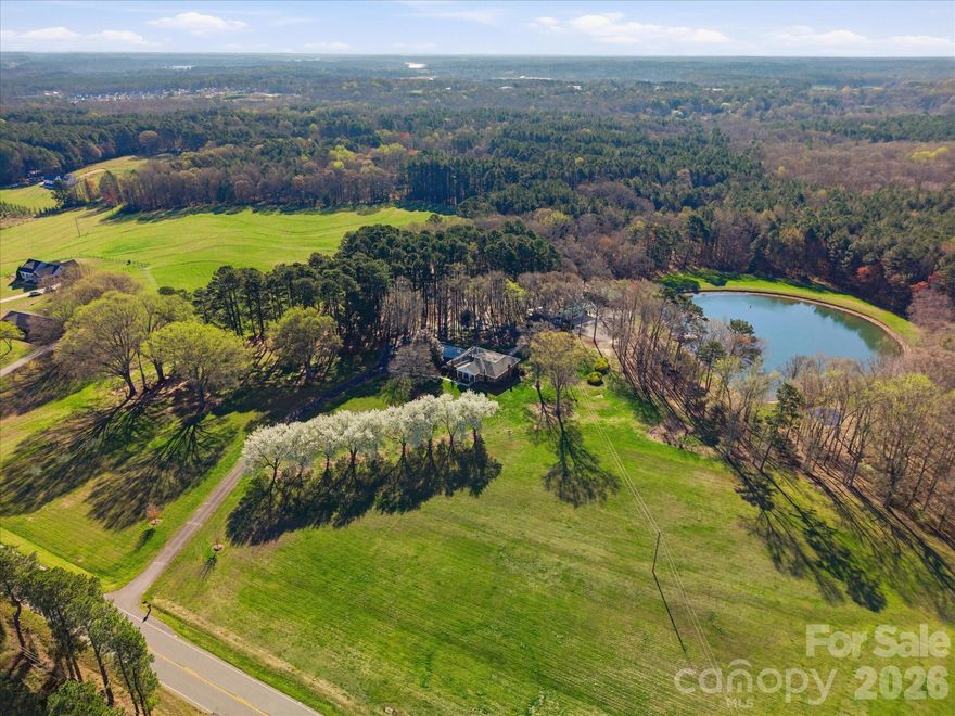 Wow – what a rare find!  This estate home has been loved by the original owners and is ready to be passed on to new buyers.  Located on two parcels with a total of over 31 acres, you have to see this property to fully comprehend all that it offers.  The main level of the primary residence has the primary bedroom, two additional bedrooms,  as well as two-and-a-half baths.  Charm and nostalgia fill this home that features unique woodwork, oversized brick fireplace with raised hearth, large living spaces, and so much more.  The primary bath has been updated with walk-in shower. You will be swept into calmness and peacefulness as you relax in the family room that provides an amazing view of the property – and a beautiful pond is at the center of it all!  With the kitchen (granite countertops), formal living room, den, dining room, and family room, you will have plenty of room to entertain on the main level.  The walk-out basement provides unlimited possibilities – game room, office, flex space, storage, and so much more!  With updates and your personal touches, this home will be a true “show stopper!”  Outdoor living takes on a whole new meaning with this property.   Looking for a place for casual parties and gatherings?  The “pondominium” is going to be your answer!  This conditioned space with kitchen and bathroom is a fabulous bonus.  With access roads throughout this property, you will have new adventures every day and room for everyone to explore.  It is going to be difficult to find another place like this one that provides such a tranquil setting with privacy, yet easy to navigate through.  The storage barns, stables, and outbuildings are welcomed additions for new owners.  This is a special place that is ready for a new generation and you could be the one to make this an estate you can be proud of for years to come!