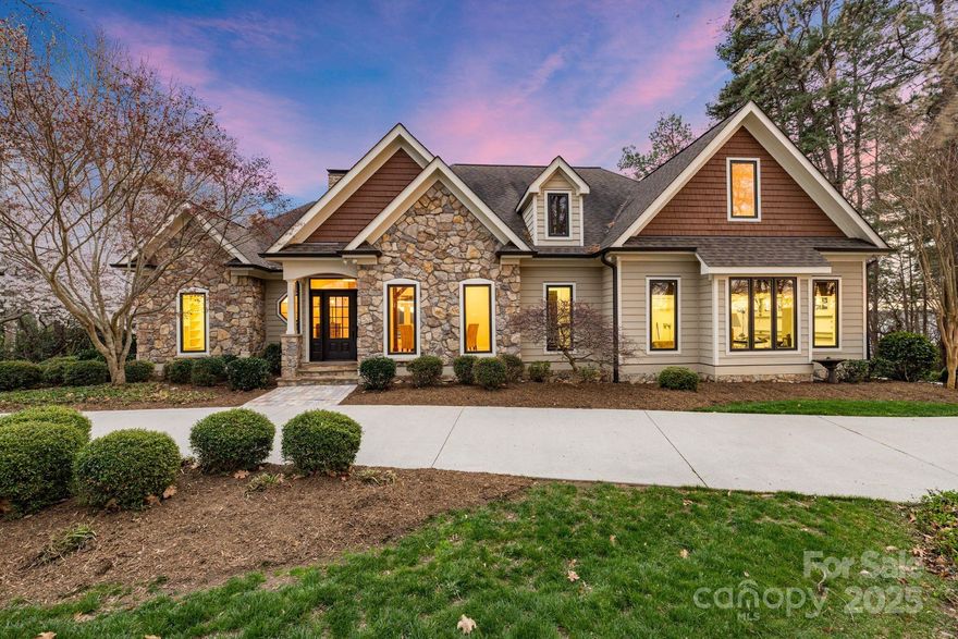 Experience lakeside living at its finest with this stunning Lake Norman waterfront home, offering breathtaking panoramic water views. With 4 spacious bedrooms and 5 and a half beautifully appointed bathrooms, this home is designed for both relaxation and entertainment. The open-concept living area creates a seamless flow throughout, with a bright and airy atmosphere that leads to a charming screened porch — perfect for enjoying the serene views. The renovated lower level provides additional living space with direct access to a private patio and covered dock, featuring two boat lifts for your convenience. A sandy beach invites you to unwind by the water, while the meticulously landscaped grounds provide a picturesque backdrop for outdoor activities. Just minutes away from the restaurants, shops, and entertainment that Lake Norman has to offer, this home provides the perfect balance of peaceful lakeside living and easy access to all the local amenities.