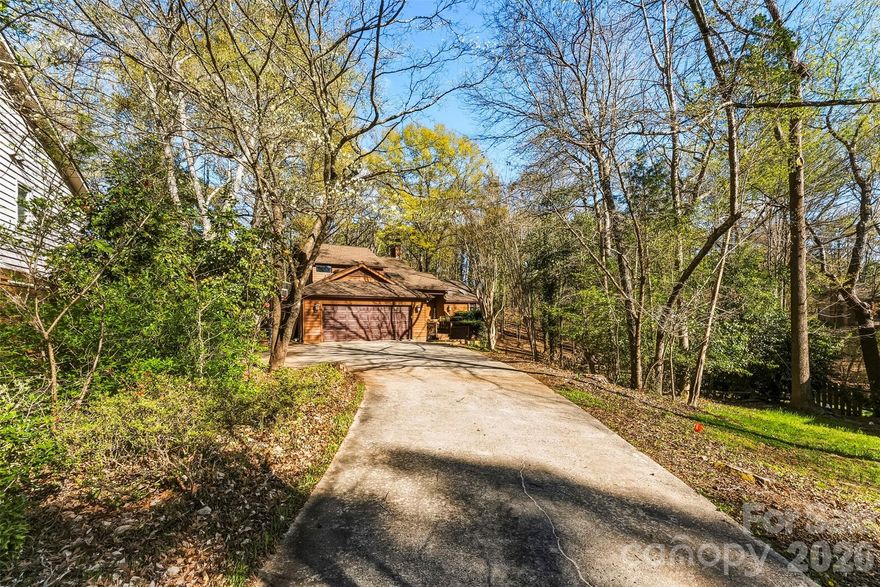 Welcome to your treehouse in the woods — inside one of the Lake Wylie's most remarkable communities.
Tucked toward the back of the prestigious, gated River Hills neighborhood on a quiet cul-de-sac, this 3-bedroom, 2.5-bath contemporary home sits on nearly half an acre surrounded by mature hardwoods, azaleas, and dogwood trees. It's private, peaceful, and completely one-of-a-kind.

The main level is designed for both everyday living and entertaining. Hardwood floors run through the foyer, kitchen, dining room, and living room. The great room features a stunning stone wood-burning fireplace and soaring ceilings. The kitchen offers a center island, solid surface countertops, and a breakfast area bathed in natural light from the adjacent sunroom — a standout space perfect for a home office, reading room, or morning retreat. The master suite is on the main level with a large walk-in closet and ensuite with new flooring. Main level laundry completes the thoughtful layout.

Upstairs, two generously sized bedrooms share a full bath with double sinks, plus a large loft ideal for a second office, playroom, or media space — and a flex room perfect for a craft room, studio, or 4th sleeping area.
Step outside to the expansive rear deck and hot tub deck — made for entertaining, and stunning in the spring when the azaleas bloom.  No lawnmower needed on this home, it's nested in it's natural surrounds.

Enjoy the outdoors with large backyard deck accessible from the living room, or sunroom.  On the back deck you'll also find a 40 jet hot tub (hardly used).  

The large unfinished basement offers serious storage and workshop potential. River Hills amenities are unmatched: gated entry, golf course, tennis and pickleball courts, fitness center, horse riding, community garden, walking trails, and direct access to Lake Wylie with a private beach. Camp Thunderbird is steps away. This home backs to the walking trail leading directly to the lake — you won't find a better location within the community.

A rare find for buyers seeking space, privacy, lifestyle, and a home that truly stands apart.