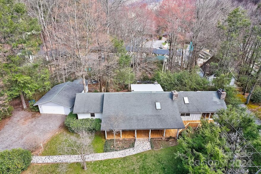 Mountain living in this contemporary log home, ideally situated in Maggie Valley. You are greeted by the soothing melody of a rushing creek just beyond your screened-in back porch. This home boasts an inviting open floor plan with exposed wood accents throughout. Gather around the the wood-burning fireplace in the expansive great room. The eat-in kitchen features gorgeous wood floors and creek views. Indulge in the luxury of one-level living, with the convenience of an in-law suite w/spa tub and front porch providing additional comfort and luxury. A detached 2-car garage with storage ensures ample space for all your recreational gear & vehicles.  The natural beauty of the surroundings 360 winter mountains views and charming fire pits; one nestled along the creek's edge.  Conveniently located in the heart of Maggie Valley, this retreat offers both serenity and accessibility.  Sold fully furnished, this is an opportunity not to be missed for those seeking the ultimate mountain getaway!
