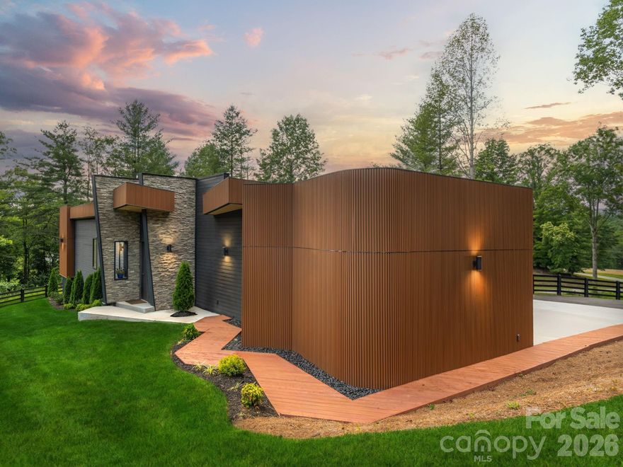 Live Inspired at Skönt at Mills River!
Welcome to a rare opportunity to own a truly distinctive modern retreat, tucked within an exclusive five-home enclave in Mills River. Designed to feel both intentional and serene, this single-level residence blends clean European architecture with the quiet beauty of the North Carolina mountains—creating a home that lives like a private escape.
At the center of the home, a custom-designed kitchen featuring Italian SMEG appliances sets the tone for thoughtful, design-forward living. Expansive windows and seamless indoor-outdoor flow fill the home with natural light, while an impressive 1,100-square-foot deck becomes an extension of everyday life—perfect for morning coffee, afternoon relaxation, and evenings surrounded by nature.
Each of the three ensuite bedrooms offers privacy and comfort, with direct access to the deck and a sense of retreat in every space. Carefully curated finishes and architectural details elevate the home throughout, striking a balance between modern sophistication and effortless livability.
Skönt at Mills River is more than a home—it’s a lifestyle defined by simplicity, intention, and calm. Now reintroduced, this is your opportunity to experience modern mountain living at its most refined.