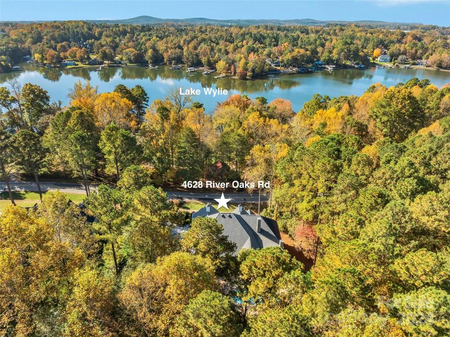 Custom Built gorgeous home across the street from Lake Wylie in The Coves on River Oaks.1.12 acre lot next to green space. Meticulously maintained, ranch style with bonus room/office upstairs. Saltwater pool, fenced backyard. Two screened porches. Primary Bedroom on main with doors to 2nd screen porch with stone fireplace. Gorgeous kitchen with granite countertops & large island for entertaining & seating. Stainless appliances, gas range, two dishwashers, refrigerator 2024, wine fridge, convection wall oven & microwave, custom cabinetry & backsplash.  Great room with gas fireplace & stunning wrought iron chandelier, plus one in dining area of the kitchen. Wrought iron front door with glass opening. Rinnai tankless water heater, irrigation, security system, gutter guards. Beautiful landscape & backyard patio, raised garden beds & gravel path to wooded area. Seasonal water view of Lake Wylie while sitting on the porch. Quality products & original owner has manuals & original build info.