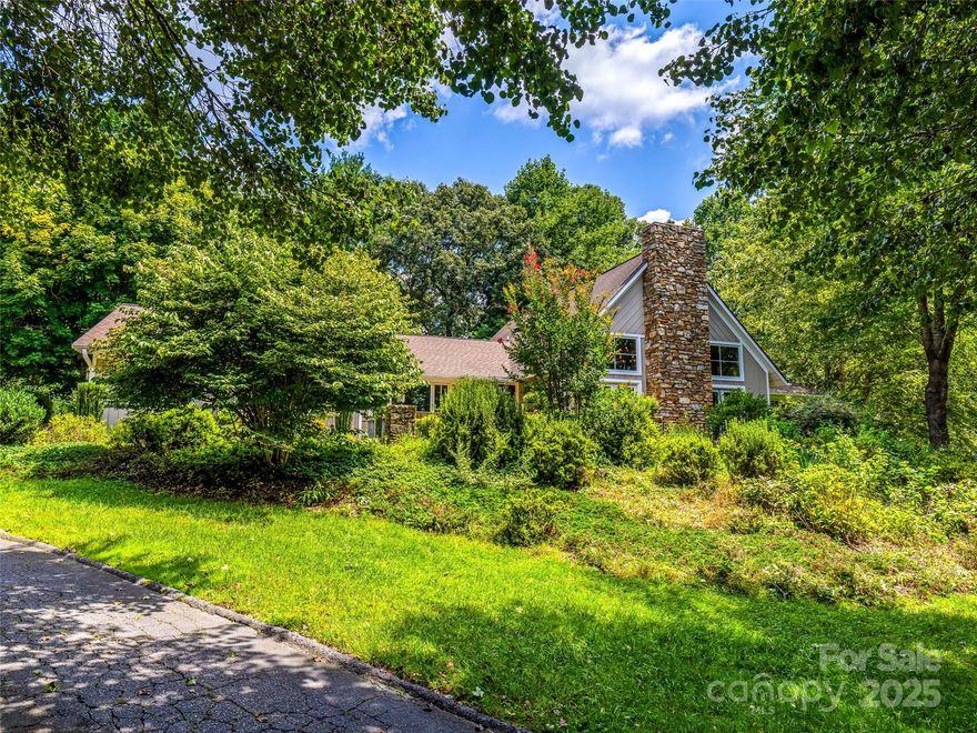 Nestled in the highly sought-after Wilson Farm neighborhood, this stunning 3BR/3.5BA ranch offers just over 2,900 SF of elegant living with a partial unfinished basement for future expansion or hobbies.  Enjoy a peaceful, park-like setting surrounded by mature trees and lush landscaping--just minutes from downtown Hendersonville and the Ecusta Trail.  The open floor plan features hardwood floors, vaulted ceilings with exposed beams, custom molding, and a dramatic living room with a brick fireplace.  A spacious kitchen with abundant cabinetry, a walk-in pantry, and a breakfast nook flows seamlessly into a cozy den and sunlit four-season room.  The split-bedroom layout includes a luxurious primary suite with a walk-in closet and spa-like bath, plus an office with a closet.  Outdoor living shines with over 500 SF of patio and a koi pond backyard ideal for pets.  This exceptional home is move-in ready!