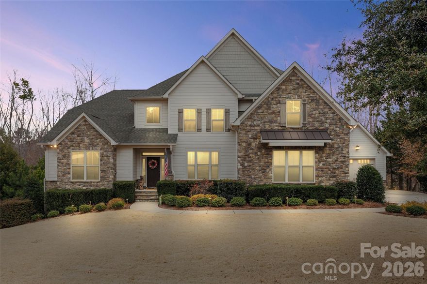 Tucked away on a private, wooded 1.4-acre lot with beautiful seasonal lake views, this exceptional property offers luxury living, resort-style amenities, and unmatched versatility all while being centrally located to Lake Wylie living and conveniently situated near all that Charlotte has to offer. From the moment you arrive, you’ll appreciate the rare combination of privacy, craftsmanship, and thoughtful upgrades that make this home an entertainer's dream with plenty of room for family and guests and even includes a 2nd Living Quarters.

The spectacular backyard is a professionally designed retreat created for both entertaining and everyday enjoyment. At the center is an impressive 18,000-gallon heated saltwater pool, enhanced by a soothing waterfall and integrated hot tub. Expansive paver decking surrounds the pool, providing ample space for lounging and gatherings. The outdoor kitchen is fully equipped with a grill and smoker, making al fresco dining effortless. Nearby, a hand-hewn natural boulder gas fire pit creates a dramatic focal point and the perfect setting for relaxing evenings under the stars.

Inside, the home continues to impress with hardwood floors and high-end finishes throughout. The main kitchen features an open concept, oversized island, dining area with stunning views, cabinets galore, GE Profile appliances, all complemented by custom California Closets organization systems in the primary bedroom closets and the kitchen pantry, blending style with function.

A standout feature of this property is the fully equipped second living quarters, ideal for multigenerational living, long-term guests, or fun family moments. This private space includes its own full kitchen, living room, dining area, primary bedroom and ensuite bathroom, offering comfort and independence without compromise.

Practicality meets luxury with an abundance of thoughtful upgrades. For ultimate convenience and peace of mind, the home includes two separate laundry rooms each with their own washer and dryer, a Generac whole-house generator, surround sound, two refrigerators, two gas ranges and a comprehensive security system with five outdoor cameras.

Boat owners, car enthusiasts, and hobbyists will appreciate the secondary garage, which is 28 feet deep and features an oversized 9-foot-high by 10.5-foot-wide door ideal for boat storage, additional vehicles, or a workshop. 

With generous acreage, seasonal lake views, resort-style outdoor living, and an incredible list of upgrades, this property offers a rare opportunity to own a private retreat that feels like a vacation destination all while enjoying the comforts of home with close proximity to all that Charlotte has to offer (only 30 minutes to uptown & the airport). This is a must see home!