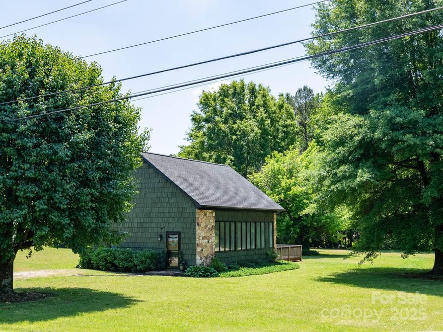 Nestled on a level 1.57-acre lot with no HOA, this charming cottage offers privacy, convenience, and investment potential. Minutes from Blythe Landing Park (with boat launch), Birkdale Village, Jetton Waterfront Park, marinas, and I-77, it's ideal for everyday living or short term rental potential. Designed with a 3-bedroom septic, it can be converted back to a full 3-bedroom layout. Interior updates include newer LVP flooring, HVAC, paint, and modern lighting. The open floor plan features soaring ceilings and a dramatic wall of windows for natural light. A spacious deck overlooks a peaceful, tree-lined backyard—perfect for relaxing or entertaining. A large shed/workshop with electricity adds storage or hobby space. Bonus: potential to subdivide—buyers should verify with the Town of Huntersville. Seller makes no representations. Great as a primary home, vacation getaway, or rental investment, this property offers charm, flexibility, and future upside.