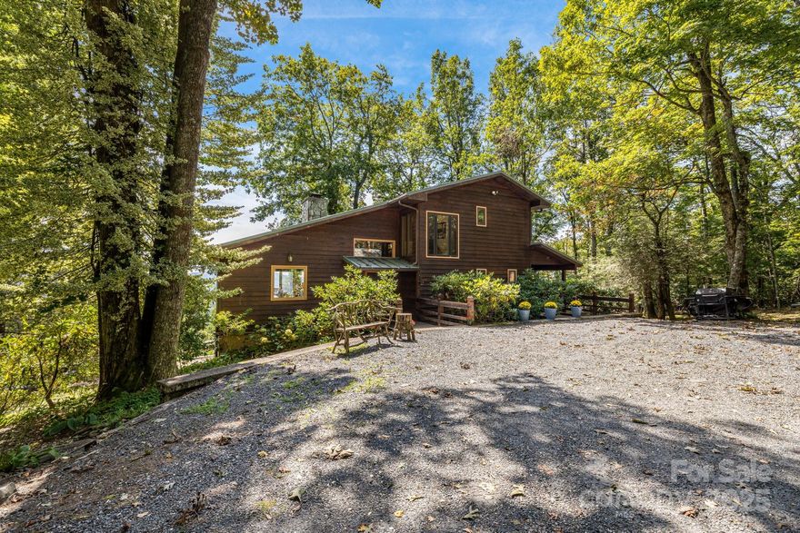 Discover a truly extraordinary opportunity to own a sprawling compound with two distinct homes, nestled on nearly 5 acres of pristine mountain land spanning McDowell and Mitchell Counties. This property offers unparalleled privacy, breathtaking long-range views and direct access to the beauty of the Pisgah National Forest. The main residence is a three bedroom 2.5 bath cabin that masterfully blends rustic charm with modern comforts. Be captivated by stunning ling range mountain views that are seamlessly integrated into the design, offering a picturesque panorama from nearly every room. The main level features a large, dedicated dining space and a cozy living area open to the kitchen. Retreat to the expansive primary suite on the second floor, accessible by your private elevator. This luxurious haven includes a separate study or work out room, a larger bathroom complete with relaxing jacuzzi tub, and a huge walk in closet. The daylight basement offers 2 additional bedrooms with walk out access. Enjoy the mountain air from multiple decks, an enclosed porch off the kitchen or from the relaxing outdoor hot tub. A generous garage/workshop with an EV charges and ample parking complete this incredible home. Just moments away sits a beautifully renovated guest house boasting 4 bedroom and 2 bathrooms on it's own 2.2 acre parcel. This pristine retreat features a large patio and a separate fire pit area, perfect for hosting family and creating unforgettable memories. With a generator hook up for peace of mind, private trails to explore and the assurance of permanent privacy as the property backs up to conservation land on one side and the Pisgah National Forest on the other, this is a rare find. Located in the coveted Little Switzerland area, this is more than a home - it's a legacy property waiting for you! Comes furnished!