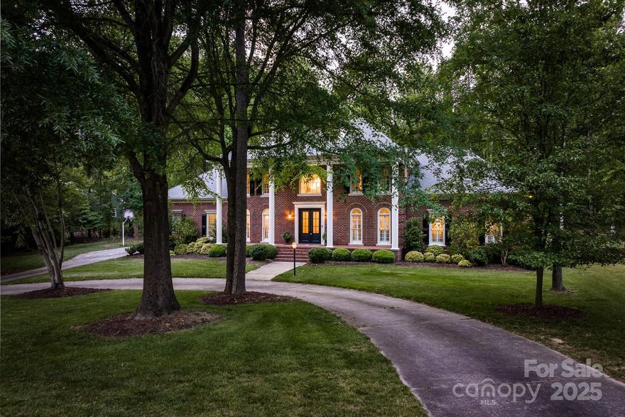 This traditional home offers a true majestic essence with it's Colonial columns, circular drive and plush greenery. Experience Southern-living at its finest in this full-brick home nestled on a private, flat, nearly 1-acre lot, in the highly sought after Providence Plantation neighborhood. The traditional floor plan boasts formal rooms, abundant natural light and soaring views of the property. Primary suite on main with fireplace, generous closets and bathroom, plus a flexible space with endless opportunity for use. Secondary bedrooms on upper level, plus sprawling bonus room. Outdoor retreat is a true escape beginning from the sun room, to the deck, to the outdoor pool, and fenced yard. Welcome to your South Charlotte dream home.