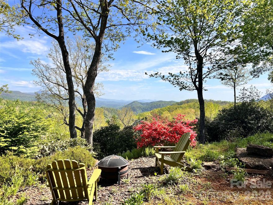 It's all about the view! It's even better in person. Perched in the heart of the Blue Ridge Mountains, 405 Glen Echo Circle is an opportunity to own a home that feels like a retreat. Imagine waking before dawn, stepping onto the screened porch, settling into the open deck, or simply sinking into the living room as the first light of day crests the ridge and the Blue Ridge Mountains unfold before you in a slow, breathtaking sunrise…just as the previous owner did, every single morning.
The 180-degree mountain views stretch across the protected Green River Gamelands. Walls of windows in nearly every room pour natural light across deep amber red oak hardwood floors, filling the home with a warmth and coziness that’s felt the moment you walk through the door. It’s one-level living at its finest, with 3 bedrooms each with its own bathroom, and long-range views everywhere you look. Vaulted ceilings soar overhead, open transom ledges connect the living spaces in a way that feels intentional and airy, and the stone gas log fireplace anchors it all. Every room brings comfort in its own way.
Step outside to find a yard that’s been loved and tended with real care. Established perennials, including rhododendron, azaleas, mountain laurel, and daffodils, return each year faithfully. A fenced front yard provides the perfect playspace for four-legged friends. Scattered boulders throughout the landscape serve as a gentle reminder that you are, in fact, living on the side of a mountain. The screened porch and double-layer open deck make outdoor living effortless, whether you’re entertaining, gardening, or simply doing nothing at all.
For the buyer ready to make it their own, the kitchen and bathrooms offer exciting renovation potential with great layouts and solid foundations already in place. The finished walk-out basement provides more possibilities as a workshop, storage, guest suite, or recreation space. With vaulted ceilings, hardwood floors, a stone fireplace, and mountain views as your starting point, the bones of this home are truly something special. There is so much to work with, and so much to love exactly as it is. With high-speed fiber internet and only 5 minutes to I-26 and 7 minutes to downtown Saluda, you’ll be conveniently connected yet in a world of your own. Retreat to mountain living and schedule your showing today! Showings will start on April 8th.