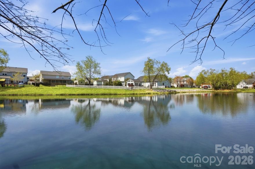Wow—this stunning waterfront home with a rare double primary suite layout offers exceptional flexibility for multi-generational living and is nestled in one of the area’s most sought-after communities, known for its beautiful tree-lined streets and resort-style amenities.

From the moment you arrive, the home’s inviting curb appeal and expansive covered front porch—complete with ceiling fans—set the tone for comfort and charm. Inside, you’re welcomed by two versatile flex spaces at the front of the home, ideal for a home office, music room, reading lounge, or sitting area, perfectly positioned across from the formal dining room.

The spacious family room features a cozy fireplace and flows into the kitchen and breakfast area, creating an open layout perfect for both everyday living and entertaining. Large windows showcase breathtaking views of the backyard oasis, bringing in natural light and serene water views.

The main-level primary suite is generously sized and features a tray ceiling along with an updated en-suite bath, complete with a double vanity, large walk-in shower, and linen closet. Upstairs, a second primary suite with a private full bathroom provides an ideal setup for guests or extended family. You’ll also find two additional bedrooms and an oversized fifth bedroom or bonus room—perfect for a media room, playroom, or fitness space.

Step outside to your private backyard retreat, where an extended patio with a retractable awning invites you to relax or entertain while enjoying peaceful views of the pond and its elegant fountain—a truly rare and tranquil setting.

This exceptional community enhances your lifestyle with multiple stocked ponds, a community pool, park, and ball courts—all surrounded by picturesque scenery.

Conveniently located in Indian Trail in Union County, this home offers easy access to shopping, dining, and easy access to both the Monroe Bypass and I485, combining peaceful living with everyday convenience.