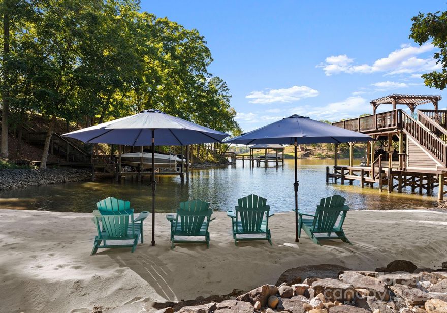 Experience the pinnacle of Lake Wylie living in this exceptional waterfront estate near Tega Cay. Nestled on over an acre of shoreline, this home blends elegance with comfort. The chef’s kitchen flows into a vaulted dining room with lake views—ideal for intimate dinners or entertaining. The great room features soaring ceilings, a statement fireplace, and access to a spacious deck overlooking the water.

The luxurious primary suite offers private deck access, vaulted ceilings, and a spa-inspired ensuite. The walk-out lower level includes a second kitchen, wine cellar, gym, and two ensuite bedrooms. A fourth ensuite bedroom above the 3-car garage provides a private guest or in-law retreat.

Enjoy your own sandy beach, double-deck dock, golf cart bay, and storage for lake toys. Just 30 minutes to Charlotte Douglas International Airport. Don’t miss this rare opportunity to own a private lakeside paradise.