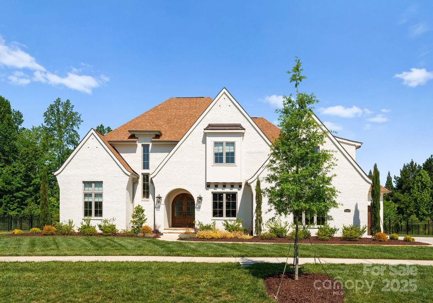 Welcome to this exquisite all-brick custom residence, built in 2022, where timeless elegance meets exceptional design. From the moment you enter the bright, inviting foyer adorned with natural hardwoods, you'll feel the warmth and sophistication that flows throughout the home. The main level features an expansive great room with fireplace—perfect for both relaxed living and elegant entertaining. The floor plan seamlessly opens into a chef’s dream kitchen w/ quartz countertops, spectacular walk-in scullery/pantry with a dedicated coffee bar and wine room. The main-level primary suite is a true retreat, featuring an oversized closet and a spa-inspired bath with a soaking tub, dual vanities, and a frameless glass shower. Upstairs you will find additional bedrooms as well as bonus spaces. Step outside to a large covered back porch overlooking a stunning pool and hot tub—an entertainer’s paradise in a private, wooded, fenced backyard. A 3-car attached garage completes this exceptional home.