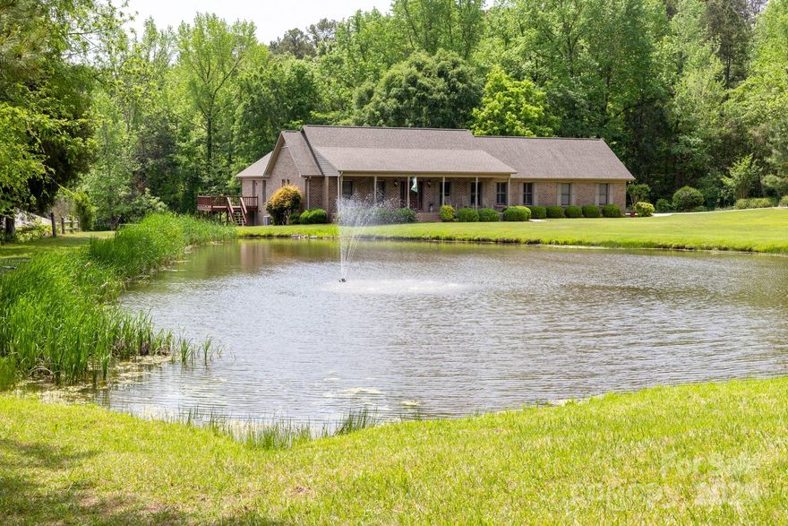 Private 6.1-acre retreat with endless lifestyle potential! This full-brick ranch overlooks a beautiful pond and features 3 beds, 2 baths, a flex/office with French doors, a spacious living room with built-ins, and an inviting kitchen/dining area. Enjoy stunning views from every bedroom and peaceful evenings on the front porch swing. With multiple outdoor living spaces — a screened porch, back deck, and a front porch overlooking the pond — this home delivers a true retreat feel. You’ll also appreciate the convenience of the attached 2-car garage.

The property is loaded with functional extras, including a tractor carport, RV hookups, an efficient wood burner for heating the home and/or workshop, several wood storage areas, and more. An oversized workshop with bathroom and upstairs space is perfect for car enthusiasts, hobbyists, or a dedicated workspace. Open acreage offers ideal potential for horses or farm use, with plenty of room for equipment, tractors, or construction needs. Beautiful garden areas and unbeatable pond views complete the picture.