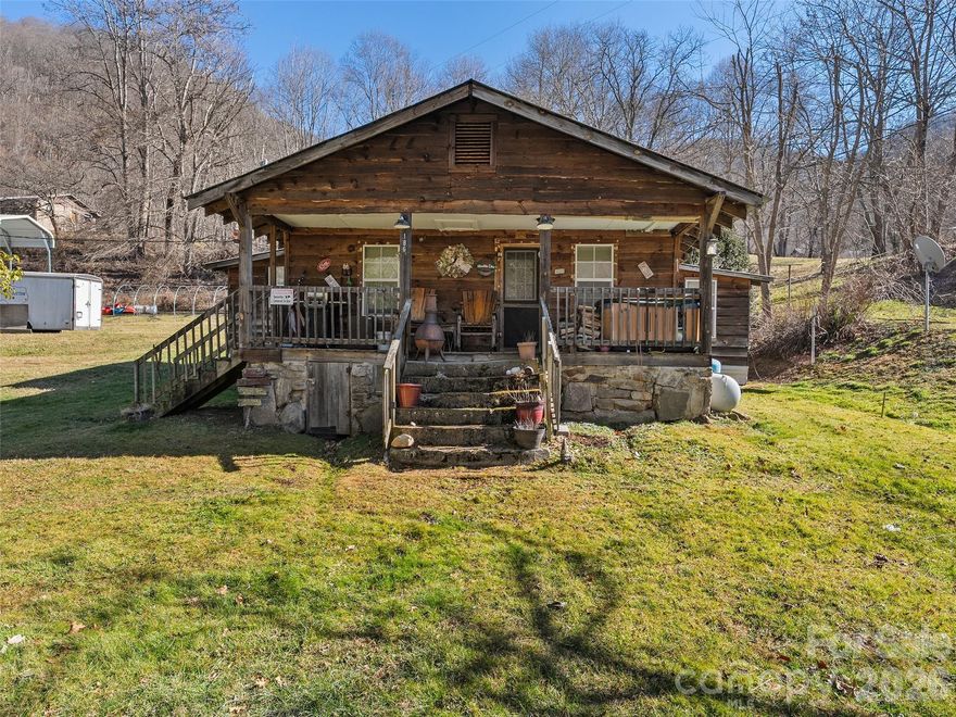 Nestled in the serene, picturesque Fines Creek and Max Patch community of Western North Carolina, this charming 744 sqft. rustic cabin offers a peaceful country retreat amid the beauty of the Appalachian Mountains. Built in 1937, the cozy 2-bedroom,(to be verified) 1-bath home features an inviting open floor plan, classic wood siding, and a durable metal roof. Warmth is provided by a propane heater and a traditional wood stove, perfect for cool evenings. The level lot includes a spacious covered front porch (7’ x 24’), RV space & carport cover, a reliable well and septic system, and two useful outbuildings for storage or hobbies. With convenient access to Highway 209 and I-40, this property combines timeless mountain character with easy connectivity to nearby towns and the renowned Max Patch bald for stunning panoramic views and outdoor adventures. Ideal for those seeking a quiet, authentic cabin lifestyle in a stunning natural setting.