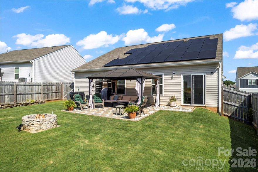 WARNING: Do NOT buy this house if you absolutely hate saving money. Seriously… if lower utility bills, helping the environment, and charging your electric vehicle right in your own garage instead of donating your paycheck to gas stations sounds terrible — this home is definitely NOT for you. And those solar panels? What a nightmare… quietly producing energy, reducing monthly expenses, and potentially adding long-term value to the home. Who would want that kind of stress? Nope, this property is patiently waiting for the "bright" buyer who will truly appreciate "watt" it’s worth — both inside & out. This energy-efficient home features a solar panel system designed to deliver immediate monthly savings, with typical payments that are often lower than the average electric bill & occasionally even credit back. Enjoy the benefits of reduced utility costs from day one, along with a more sustainable lifestyle. As the loan progresses toward payoff, the system is projected to contribute an estimated $10,000–$20,000 in added resale value, making it a smart long-term investment. Combined with the home’s overall appeal, this solar advantage offers both present-day affordability and future financial upside.  If homes had personalities, this 2020 stunner would be the overachiever who shows up early, brings snacks, and still looks flawless. Featuring 3 bedrooms, 2 full baths, and a 2-car garage, this beauty checks more boxes than a moving company inventory sheet. The open floor plan flows smoother than sweet tea on a July afternoon, making it perfect for hosting, boasting, and maybe a little humble-bragging. The fenced backyard? It is ready for dogs, kickballs, grill nights, or that “accidental” second helping of burgers. Whether you’re throwing a party or just throwing a ball, this yard has you covered. Now let’s talk about the real power move… solar panels. These panels are designed to practically eliminate your electric bill. That means the only thing shocking around here is how good this deal is. Your wallet might finally get a tan from all that sunshine savings. Thinking about new construction? Why wait on dirt when this one is already dessert?  Built in 2020, lightly lived in, and dialed in. No dust. No delays. No guessing games. And yes… the price has been reduced. The sellers are motivated and ready to entertain all offers. This is not a drill. This is your sign, your signal, your flashing neon “don’t let someone else buy my house” moment. Bottom line: If you’ve been on the fence, hop off it. (This yard already has one.) Schedule the showing. Fall in love. Make the offer. Because the only thing better than dad jokes… is owning the house that comes with them.