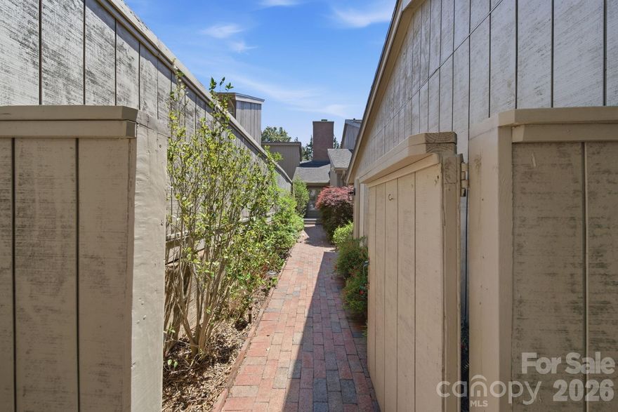 Welcome to this spacious and beautifully maintained townhome nestled in a charming community in SouthPark. From the moment you step through the gated entrance, you'll be captivated by the serene courtyard featuring brick walkways, a welcoming front porch, and a generous side deck—perfect for relaxing or entertaining.  Inside, the open layout offers a neutral palette and abundant natural light. The great room boasts a dual-sided fireplace shared with the sunroom, creating cozy ambiance throughout. The kitchen has with white cabinetry, ceramic tile backsplash, granite countertops, and stainless-steel Bosch appliances including a gas cooktop, wall oven, microwave, and dishwasher.  Step out from the kitchen onto a sprawling deck ideal for outdoor gatherings. The main-level primary suite offers direct access to a covered rear deck—perfect for morning coffee or evening unwinding. The en-suite bath features dual vanities and a spacious tiled shower.  Upstairs, you'll find two generously sized bedrooms, each with its own full bath. One bedroom includes custom built-ins and a convenient Murphy bed, offering flexibility for guests or a home office. Additional highlights include wood flooring & prefinished wood throughout both levels and the staircase, plantation blinds, ceiling fans and ample storage space. Crawl space was encapsulated 5 years ago.  Located in the sought-after SouthPark area, you're just minutes from premier shopping, dining, grocery stores, and scenic greenways.