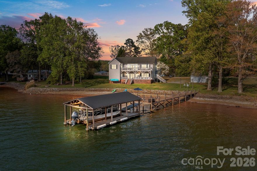 Rare opportunity to own over 220 feet of prime Lake Norman shoreline on a flat, usable lot just off the main channel — with deep water, long-range west-facing views, and NO HOA. Whether you're seeking a personal retreat, vacation rental, or a multigenerational compound, this property delivers true versatility in one of the lake's most desirable corridors — and the surrounding area is actively developing. Currently operating as a VRBO rental, this lakefront home offers consistent income potential.  

The recently updated 3,200+ sq ft home is designed for effortless lake living across two fully functional levels. The upper level is built for entertaining — a spacious lakeside great room flows to a 440 sq ft deck perfectly positioned for westward sunset views and front-row seats to all the lake action. The renovated kitchen features painted cabinetry, stone counters, a large island, stainless steel appliances, and exceptional storage, opening to a generous dining area ideal for gathering. The oversized primary suite offers lake views, a renovated bath, and an attached sitting room that flexes beautifully as a family suite or guest overflow. A powder room and full-size laundry complete this level.

The main level is equally impressive — an open living and dining area serves perfectly as a recreation room or self-contained second living quarters, with 2 bedrooms, 2 full baths, a kitchenette, and an additional flex space ideal as a playroom or guest room. A main-level deck provides daytime shade and direct access to the flat lakeside yard.

At the water's edge, a permanent private dock with platform and covered boat slip accommodates up to 4,500 lbs. The flat yard is made for fun — hammock swings, a firepit, and room to roam, all with that deep-water, channel-adjacent frontage that's increasingly hard to find at this price point.

Properties with this combination of lakefront footage and versatility don't come available often.