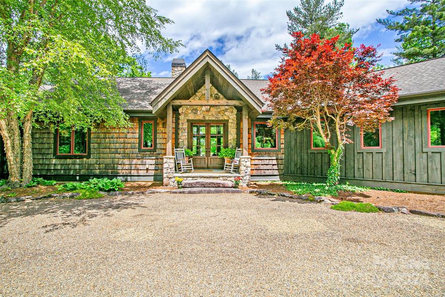 The epitome of mountain living, this custom home is situated on over 6 sprawling acres less than 10 minutes to downtown Brevard and features a beautiful setting with views of Dunns Rock. As you come up the meandering drive, you are met by a quintessential mountain home with high-end building materials, a spacious layout, all against a back drop of mountain views. Inside, discover soaring ceilings, floor-to-ceiling stone fireplace and an open floor plan that leads to the outdoors with custom stone patio area and nice porches. The kitchen features granite countertops, island, and walk-in pantry.  Main level master suite has private bath with soaking tub and walk-in shower, and the basement offers an additional family room with bar area, stone fireplace, plus a bedroom and full bath. Discover this unique opportunity for luxurious living nestled among rolling hills and pastures, near the French Broad River and minutes to downtown - all with minimal restrictions and ample privacy.
