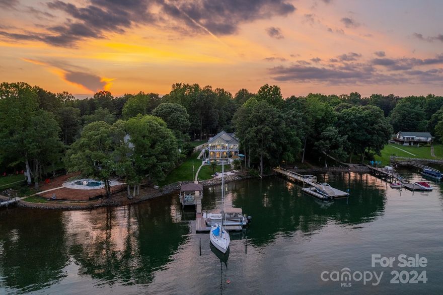 A sanctuary of lakeside splendor, offering long range, beautiful views of Lake Norman. Expansive windows frame the lake, infusing the interior with natural light and a sense of connection to the outdoors. Relax in this outdoor retreat with a pool and patio by the lake. Lounge poolside, or retreat to the shaded tiki bar on the covered dock. This outdoor oasis becomes a haven for relaxation. The open concept connects the kitchen, dining, and living areas, creating a fluid space for entertaining. Vaulted ceilings and modern updates enhance the aesthetic appeal. Primary suite with vaulted ceilings frame the gorgeous lake views. Enjoy retiring to the balcony to soak in lake views for the evening. Host movie and game nights in the cozy entertainment room, complete with a stylish wet bar. Two bedrooms and a bathroom provide comfort and convenience for overnight guests, that will enjoy immediate access to the pool and patio area. A generous workshop area with carport and oversized one-car.