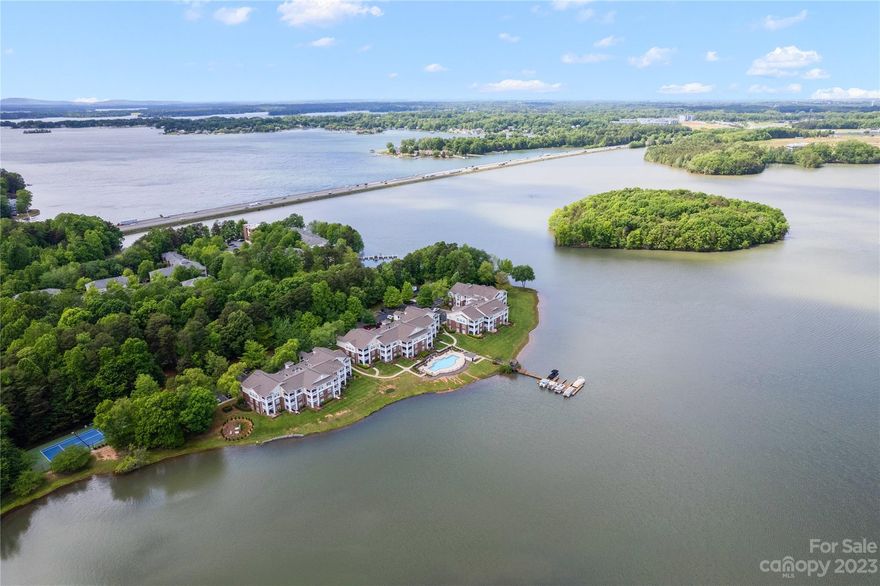 Imagine waking up to stunning sunrises over a serene lake, w/bald eagles soaring overhead. This exquisite waterfront unit offers just that! Located on the 3rd fl. w/elevator access, it provides one of the best views of Lake Davidson. Primary bedroom w/an oversized window offers refreshing breezes & stunning views. Unwind in the primary shower w/its vertical spa feature. The kitchen is upgraded w/granite counters, a farm sink, & European cabinets w/under cabinet lighting. Enjoy coffee/wine on the covered deck while taking in the scenic views & wildlife. The community offers direct lake access & dock, an inground pool, paddle sport launch, tennis courts, & a book exchg station. The nature preserve is ideal for outdoor activities. Just a short walk to Davidson w/ 5-star restaurants, shopping, movie theater, & town activities. This waterfront unit presents an exceptional opportunity for those seeking an everyday vacation home or a 2nd home w/awe-inspiring surroundings & a serene paradise!