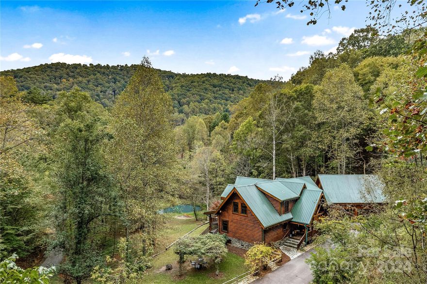 Private mountain retreat nestled away on 44+ acres in the embrace of nature's grandeur. This is not just a residence, it's an experience! Welcome to this compound style setting with room for everyone to have their own space while fostering a sense of togetherness. Offering a stunning custom-built log home filled with divine craftsmanship, 3 bedrooms, 2 1/2 baths & 5" Tigerwood wood floors. Two-story 2 bed/2 bath guest home & a 4316 sq. ft. heated workshop that boasts boundless opportunities for creativity & productivity. Enjoy an outdoor haven w/a stocked pond filled w/several types of fish, ATV trails that wind up along the ridgeline, several creeks throughout the property-some are spring fed, an abundance of fresh herbs & fruit trees that include Apple, Fig, Sour Cherry & Persimmon. All this & you're within a mile to French Broad River access w/a public park & just 30 mins to Downtown Asheville. This is a place of adventure, solitude & somewhere to create memories to last a lifetime!
