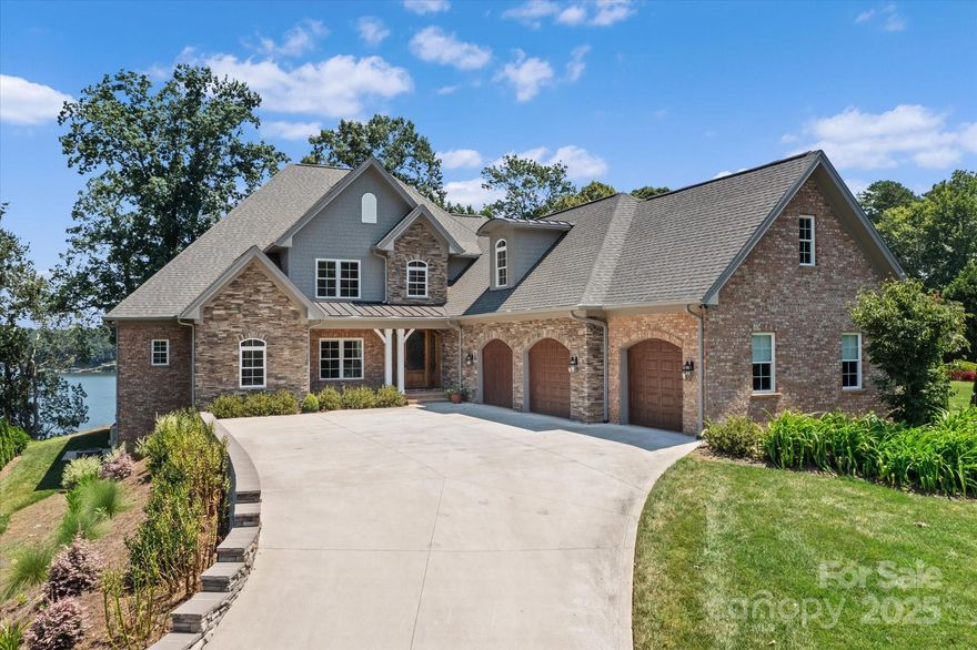 Set on the shores of Lake Norman in the gated community of Astoria, this waterfront home is ideal for entertaining, multi-generational living, or unforgettable lake retreats. The open floor plan showcases stunning main channel views. A chef’s kitchen features a wall oven/microwave combo, electric cooktop (gas hookup), and 2 dishwashers. Main-level includes primary and a guest suite, both w/ heated bathroom floors, plus elevator access to all levels. Upstairs offers 2 bedrooms, full bath, bonus room, and game room w/ wet bar and screened porch. The basement includes a rec room, full bath w/ steam shower, and 2,000+ sq ft of unfinished space. Take a short golf cart ride or walk to your deeded boat slip. Enjoy sunrises and wildlife from the veranda and patio. Additional features: power blinds on most of main level, outdoor kitchen, whole-house Wi-Fi and generator. Surrounded by woodlands, Astoria offers privacy & miles of trails—45 min. to Charlotte airport. Priced below recent appraisal.