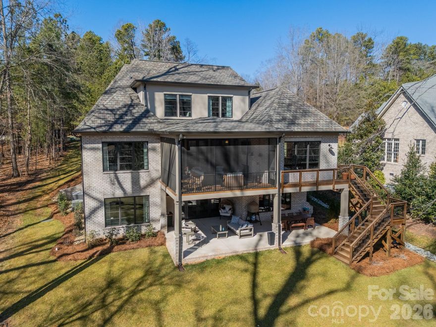 Welcome to 1521 Reflection Pointe Boulevard, a custom-built residence designed by the award-winning team at Vinyet Architecture, located within the gated waterfront community of Reflection Pointe on Lake Wylie. Tucked along a quiet inlet with dockable waterfront access, the home offers a rare combination of privacy, thoughtful design, and beautiful water views framed by expansive windows.
The main level features an open-concept layout centered around a chef’s kitchen with custom cabinetry, oversized island, professional-grade appliances, integrated refrigerator and freezer columns, and a scullery-style pantry with beverage center. The kitchen flows naturally into the dining area and a cozy den with fireplace, while the great room opens directly to the upper deck overlooking the lake, creating an easy connection between indoor and outdoor living.
The main-level primary suite offers a peaceful retreat, entered through a concealed flush-entry door and filled with natural light. The suite enjoys private deck access along with a spa-inspired bath featuring a freestanding soaking tub, walk-in shower, and generous custom closet.
The finished lower level adds flexible living space with a large living room, additional bedroom and bath, private office, dedicated home gym, and bonus space suited for entertaining, guests, or extended living.
Upstairs, a loft provides additional gathering space along with two bedrooms, one with an ensuite bath and the other served by a full hall bath, both positioned to capture lake views.
Outside, the flat backyard stretches gently toward the protected inlet, offering an ideal setting for a future pool, outdoor kitchen, or expanded outdoor living area. With dockable potential, the property presents an exciting opportunity to further enhance the waterfront lifestyle.
Residents of Reflection Pointe enjoy a gated entrance, waterfront clubhouse, resort-style pool, tennis courts, walking trails, and community recreation.
1521 Reflection Pointe Boulevard offers a rare opportunity to enjoy custom architecture, waterfront living, and a vibrant lake community just outside Charlotte.