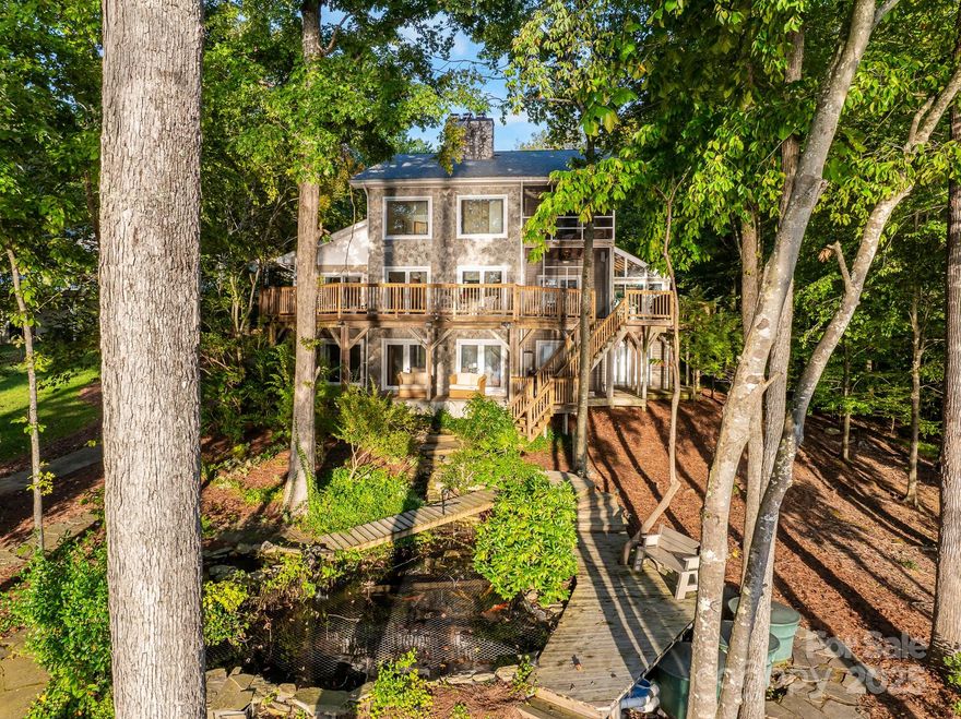 Lakefront living on beautiful High Rock Lake! Welcome to 122 Mountain Harbor Drive! This incredible estate offers over 4000sqft of living space! This home also includes a 1,800+ sq ft heated rec center not counted in total heated area, all on over 3 acres of land! The main home features a recently renovated primary bath, 2 main level bedrooms, screened porches, sunroom, office, theatre room and wraparound decks. Outdoor amenities include a koi pond with waterfalls, bocce ball court, riding trails, and a private pier! Detached 6+ car garage plus 2-car attached and 1,700+ sq ft unfinished area with HVAC in place. This building has a workout space, racquetball court and additional attic space for expansion! Currently used as a private residence and an AirBNB! Truly too much to list for this one of a kind home! The potential for more revenue is here! Don't miss out on the best value for this type of home on one of North Carolina's largest lakes! Truly too much to list! See it today!