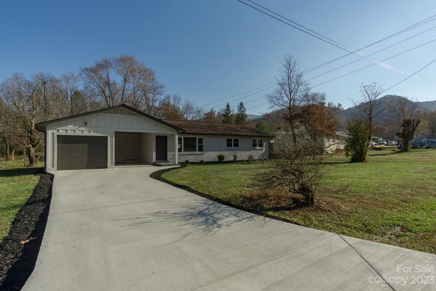 122 Hidden Valley Circle is a fully remodeled 1460 square foot, 4 bed/2 bath home located in Canton, NC. The home sits on a 0.37-acre flat lot with a new concrete driveway to access the one-car garage and additional covered carport.The main entry of 122 Hidden Valley Circle opens into the large front living room, complete with an entire wall of custom built-in shelving, recessed lighting, and large combination window that allows plenty of natural light. The kitchen features a breakfast bar, granite countertops, soft-close cabinets, and new stainless-steel appliances. The dining area contains a fireplace with custom mantel plus door leading out to the spacious back deck. The master bedroom sits at one end of the home and has a custom fully built-in closet and a full master bath with walk-in shower. The three additional bedrooms (or home office) are located at the opposite end of the home along with the second full bathroom and utility room.
