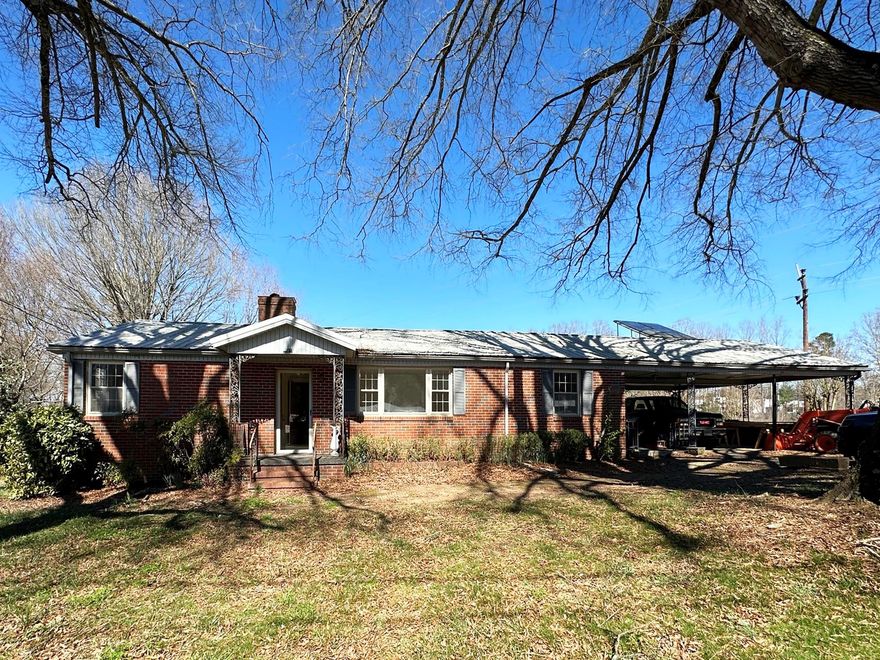 LOADS OF POTENTIAL! This all brick ranch needs someone with a vision to bring it back from it's former glory but has a ton of charm and land to boot. Situated on 3.14 Acres and conveniently located, on a no outlet street. The home features: Large Living Room, Kitchen with Breakfast Nook, Spacious Dining Room, Sunroom with woodstove, Bonus Room/Flex Space for Home Office/Craft or Play Room, etc. 2 Bedrooms, 1 Shared Full Bath and 1 Half Bath for guest's convenience, 2-car attached Carport, Side Porch, Partial Basement with garage door. There is a small barn/outbuilding with power to store your tools, a larger barn/workshop with power and an amazing metal tractor shed with shop area, that was used for years as a sawmill and is separately metered for electricity (re-built in 2010). Ample space and a well on the property for gardening. No Restrictions!
