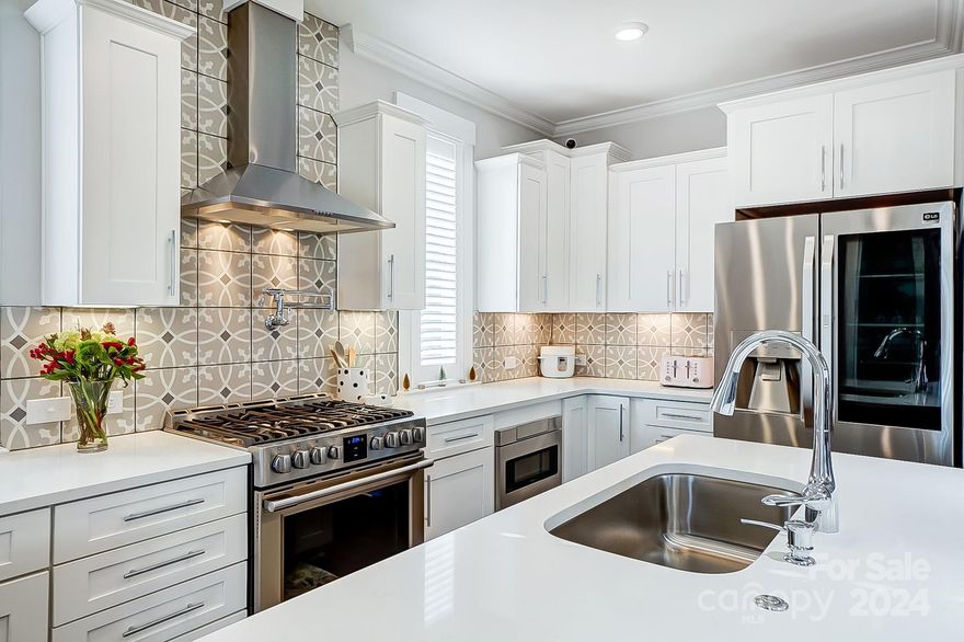 This stunning Craftsman-style home offers the perfect blend of modern convenience and timeless design in the highly sought-after Riverwalk community. Cooking is a delight in the chef’s kitchen, featuring professional-grade appliances, including a gas range with pot filler, convection oven/air fryer, and sleek quartz countertops. Enjoy drinks or coffee at the built-in bar, complete with a separate sink and wine fridge—an entertainer’s dream! Natural light pours into the open living and dining spaces while the main level study provides a quiet retreat for working from home. Luxury vinyl plank flooring flows seamlessly throughout. The primary suite is a true retreat, with a tray ceiling, dual custom closets, and an oversized rain shower. Two additional bedrooms share a lavish bath. Outdoor living shines with a rocking chair front porch, second-story screened balcony, rear covered porch, and fenced backyard. Thoughtfully designed and move-in ready! Don't miss your chance to call this home!