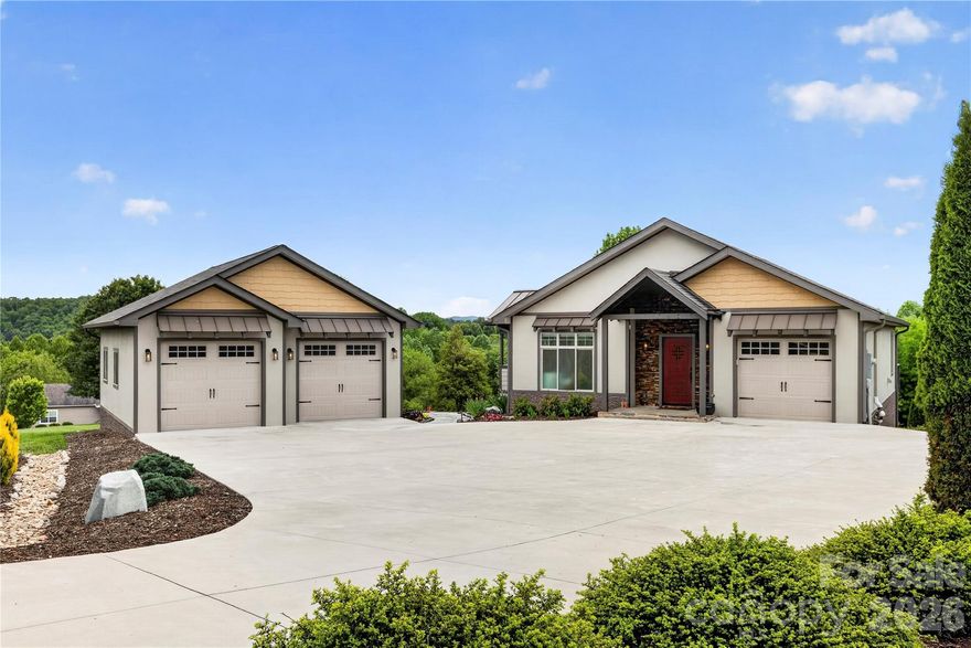 Designed with both style and comfort in mind, this beautifully crafted home showcases modern elegance at every turn. Expansive windows, crisp contemporary finishes, and an open-concept layout create a seamless sense of light and space. Every detail of this exceptional home has been thoughtfully curated to deliver effortless modern living. Step into the welcoming foyer and immediately take in the open floor plan, highlighted by a dramatic wall of windows showcasing beautiful views. The main level features a spacious great room and a well-appointed kitchen with high-end upgrades throughout. The primary suite on the main level offers a true retreat, complete with an incredible spa-like bath, dual closets, and access to a private covered side porch—perfect for relaxing in peace. The finished lower level expands your living space with a large family room, a bonus area ideal for a media space, two additional bedrooms, a full bath, and a well-equipped laundry room with sink and extra storage. A newer detached two-car garage with a lift adds even more functionality for car enthusiasts, hobbyists, or additional storage needs. Spanning 1.58 acres, the grounds provide a generous and functional outdoor space—ideal for gardening, recreation, or entertaining.