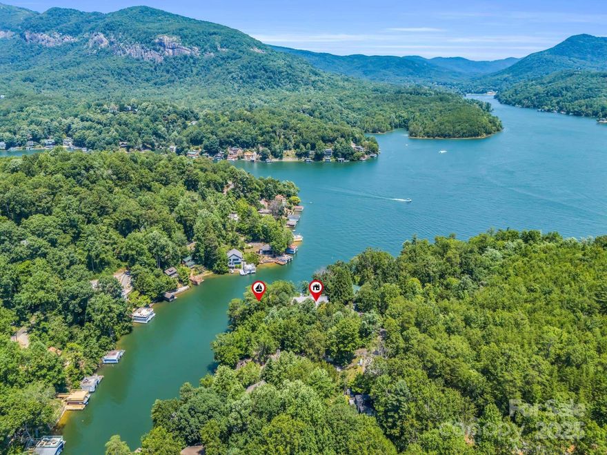 Beautifully updated home overlooking the center of Lake Lure and surrounding mountains. Situated at the mouth of a quiet cove, great for floating by the 2-lift, open boathouse w/ large sun deck. Stunning views throughout the home, decks, & boat house. Recent updates include a total rebuild of the primary bedroom, bathroom and closet; 2 gorgeous solid wood front entry doors; new sliders in the main living room & finished basement family room w/ new luxury vinyl plank floors; half bath added on the main level; new HVAC unit for the main level (lower level new in 2015). Exterior updates: Clapboard fiber cement siding and trim; paint; gutters; under deck dry install; new cable railing system on front porch; stone pathways from the parking area leading to the front entry; stonework on porch pillars and chimney stack. Convenient to grocery, shopping, town, equestrian center (TIEC), local wineries and much more. What are you waiting for? Pull up the moving van and start living the lake life!
