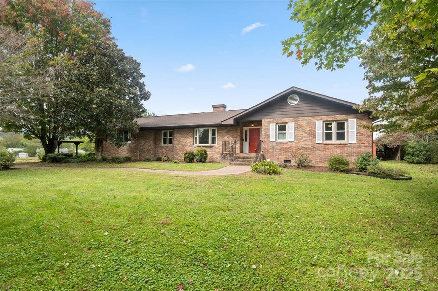 Located within minutes to the heart of Brevard and Brevard College, this 3 bedroom, 2 bath one level home boasts a private half acre lot, a two car garage,  detached workshop, and so much more. This classic brick ranch has a low maintenance exterior and a light, bright interior. Enjoy relaxing in the sun room complete with a fireplace.  The primary suite has an updated bath with walk-in shower. The kitchen has also been updated and there is a cozy brick fireplace between the kitchen and breakfast nook. The home includes a formal dining area which would also make a great home office.  If you are looking for the best of both worlds with a convenient location and a little elbow room, this home may very well be the one.