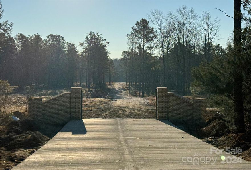 Embrace the serenity of nature on your very own private, 8-acre wooded sanctuary in the desirable Waxhaw countryside. Enjoy the luxury of being part of an intimate, gated community where large lots and a shared appreciation for privacy set the stage for an elevated way of living. Homesite comes with a 4 bedroom septic permit & features lush woodlands with towering trees, native flora, and shared access to a tranquil pond. Whether you're fishing, enjoying a peaceful paddle, or simply enjoying the view, this natural water feature will quickly become your haven of calm. Your journey home begins with a scenic drive along a well built private gravel driveway that winds through the community's gated entrance and continues around the pond. Located minutes from downtown Waxhaw, you'll enjoy easy access to local shops, dining, cultural events, & all the modern conveniences you desire. Embrace the best of both worlds - escape to nature, while still being part of a vibrant community.