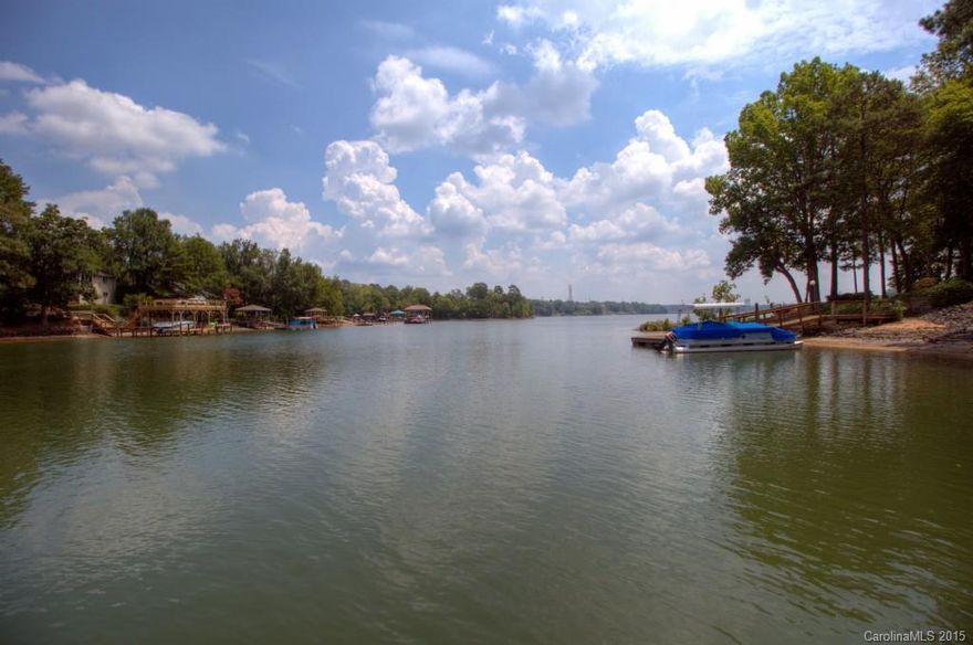 Waterfront treasure in Tega Cay! Two story home with 4 bedrooms, two on each level. Dock and lift at the mouth of an inlet, with glorious main channel views.  Living room open to kitchen, with screen porch and multiple decks. Large den on lower level, with plumbing for a wet bar. Terraced landscaping for easy access to lake, natural beauty. Updates throughout, ready for you to move in and call it home! Excellent schools, golf course and tennis, plenty of recreational fields and walking trails.