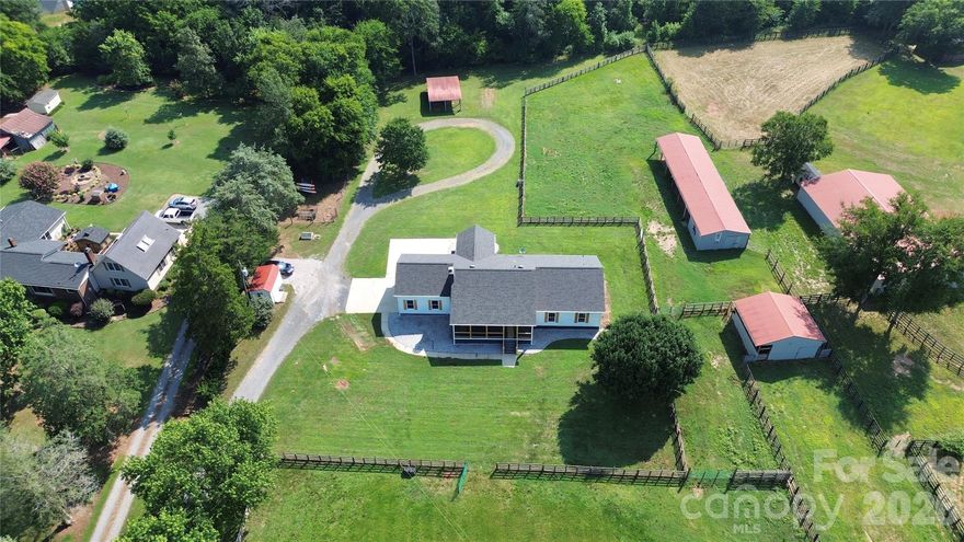 Must-see, fully remodeled equestrian ranch on 5.47 acres in Rock Hill, SC—just minutes from I-77. This turnkey property seamlessly blends modern farmhouse design with exceptional equestrian amenities, offering both a private retreat and outstanding income-producing potential.
The beautifully updated 3-bedroom, 3-bath ranch features an open-concept layout with rich hardwood floors and a striking backlit stone fireplace that anchors the main living space. The designer kitchen is a standout, complete with granite countertops, a supersized island, and a custom hidden pantry—perfect for both everyday living and entertaining. Luxuriously updated bathrooms reflect timeless style and quality craftsmanship throughout.
Equestrians will appreciate the thoughtfully designed facilities, including three barns with a total of 13 stalls—featuring European-style stalls in the main barn—along with two tack rooms and two additional storage areas and just shy of 3,000sqft.  The property also includes multiple fenced pastures and paddocks, plus a circular corral, making it ideal for boarding, training, or personal use.
With its established infrastructure, this property presents excellent opportunities for income generation, including horse boarding, training programs, or a boutique equestrian business.
Turnkey, stylish, and serene—this is a rare opportunity to own a versatile equestrian property with both lifestyle appeal and business potential.