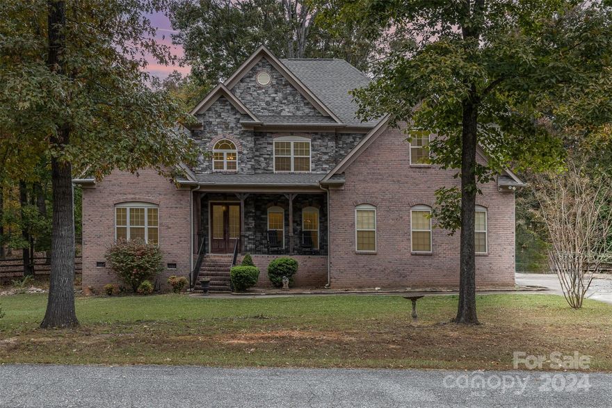 Experience fine country living on this stunning 1-acre wooded lot that adjoins the prestigious Manor House Estate. Just under a mile from the expansive 350-acre Cane Creek Park lake, this beautiful stone and brick home features soaring 10-foot ceilings and 8-foot doors throughout the main level. Enjoy a blend of hardwood, tile, and carpet flooring, complemented by elegant 42-inch cabinetry and a luxurious granite kitchen. The open, two-story living room provides a grand atmosphere, while the spacious tiled shower with dual shower heads and a relaxing jetted bathtub add a touch of indulgence. Don't miss out on this perfect retreat!