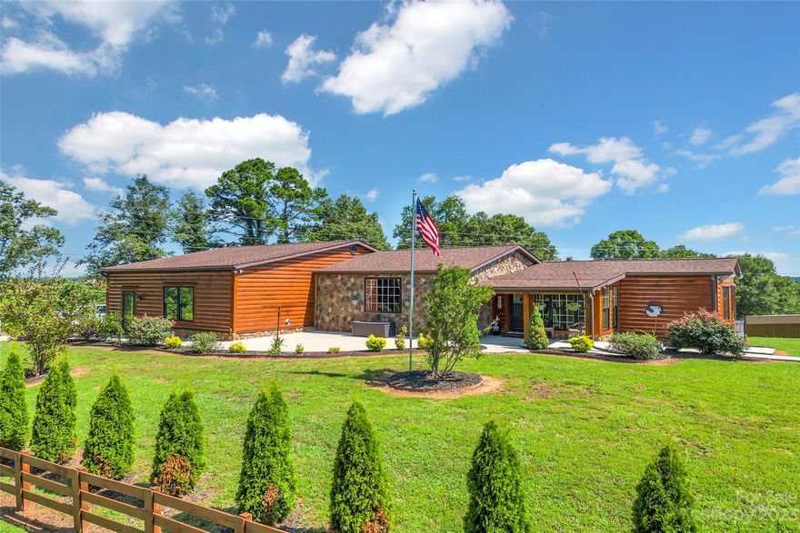 This home is looking for that special buyer who loves country living, has hobbies such as working on cars, woodworking or needs plenty of space for outdoor toys! The 4-car garage with lifts, workshop, and loft space for lots of storage is every man’s dream. In addition to the garage there is also a 3-car attached carport. This unique home started out as a mobile home that has been de-titled and then gutted and added onto by a very skilled owner. There are 2 lots being sold together. The house sits on one lot and the large garage on the other. There are septic tanks and water taps on both properties. A screened in area houses a beautiful hot tub between the house and the garage area. The landscaping is phenomenal, and the workmanship of the additions is very impressive. This home boasts of that mountain, cabin feel with lots of wood, rock, and unique décor. The large great room was once a garage that was converted into entertainment space once the big, detached garage was complete.