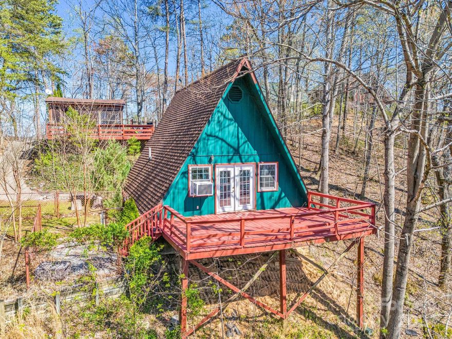 MILLION DOLLAR VIEW! 1BD/1BA A-Frame tucked away features the privacy you desire, or share it with family and friends. PERFECT weekend get away or full time residence. French doors on front deck invite you in to the open family room/kitchen area! Sleeping area/flex space, and full bath has shower only. Primary bedroom on upper level. Hilltop Tavern boasts the same MILLION DOLLAR VIEW and entertaining possibilities. Gravel parking spaces at the road for Hilltop Tavern, or use the drive down to the house. Small fenced area and utility building conveys. Enjoy the amenities at Riverbend which include 2 private lakes and the River Swimming Hole for paddle boards, canoes, kayaks, tubing, and fishing. The community pavilion features a white sand beach for swimming, picnicking, private gatherings, and community potlucks! Nature Trail follows the river with picnic areas and a small waterfall. Conveniently located to shopping, restaurants, and major highways. A MUST SEE!