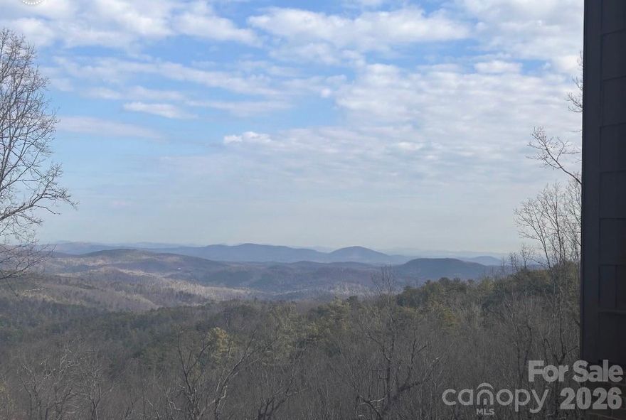 Not a painting, not a screensaver — this is the real view from your sunroom, miles of rolling mountain peaks that shift with the light and make you forget what day it is. Set on over an acre, the home feels like a cozy mountain escape with just the right touch of luxury. Step inside and the view greets you immediately, thanks to an open floor plan that draws your eyes straight through the windows and out to the mountains beyond. The main level offers three bedrooms and two baths, an expanded kitchen made for gathering, and the soft glow of a wood-burning fireplace that makes cool evenings feel extra inviting. Downstairs, the walk-out basement adds a private fourth bedroom and two full bath, opens to a patio where the scenery follows you outside, and includes a dedicated workshop space. Come see it in person because the view is even better when you're standing in it. Please do not walk the property without an appointment or an agent.