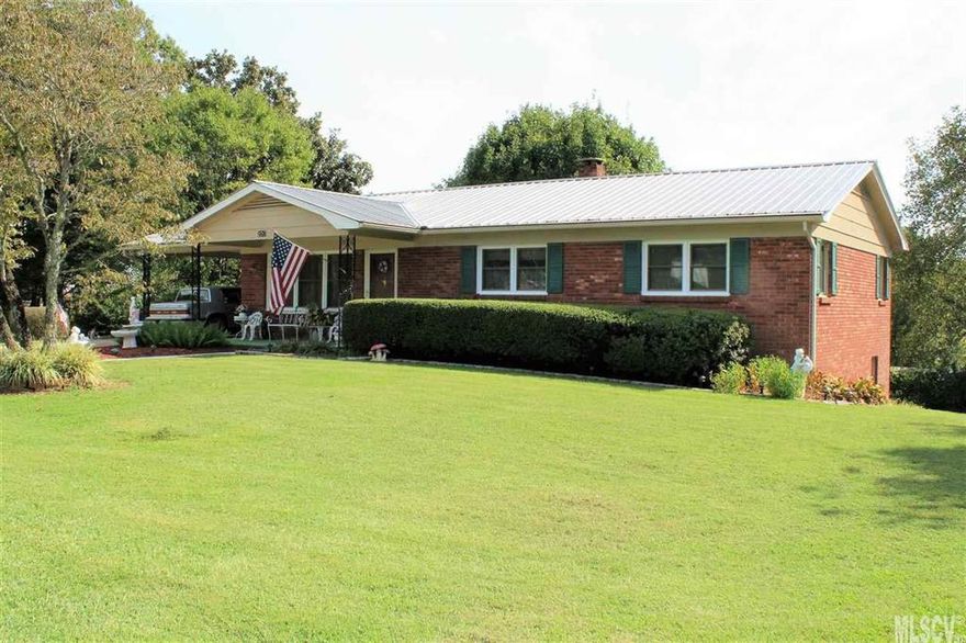 3 bedroom, 1.5 bath, brick home with full basement that has been meticulously cared for. Replacement windows and metal roof. Hardwood floors in all 3 bedrooms, and hardwood under carpet in hallway and living room. Sliding door from dining area to back deck.  Nice front porch. Beautiful level .7 acre yard. Immaculate basement with garage door to back yard. Great workshop space. Property includes 2 lots. Located in town of Cajah Mtn. but no city taxes.