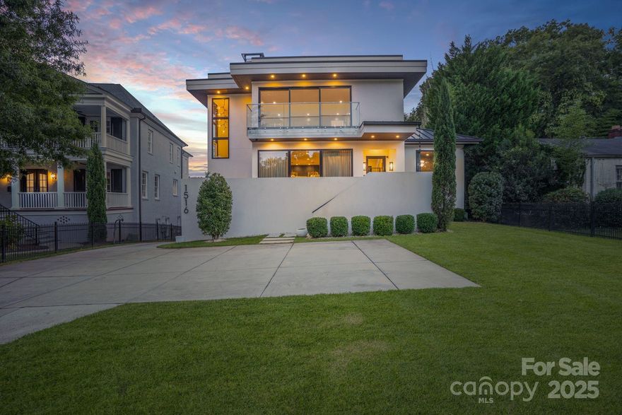 With over 7,200 square feet of heated living space, this stunning TRUE MODERN, Frank Smith–designed home offers a rare opportunity to live in a work of art overlooking the 7-acre lake at Freedom Park. Designed to embrace an outdoor lifestyle, this residence is pure luxury. The exterior features of this Modern Luxury include surround sound, a mounted TV under a covered back patio with remote-controlled shades, and a complete security system with 6 cameras plus remote controls for everything from indoor/outdoor fireplaces to exterior walls that disappear at the touch of a button. Throughout the home, you’ll find 10” wide engineered wood floors, sliding glass walls opening to a side-yard with outdoor living area, heated pool, putting green, and built-in grill & pizza oven. The custom Hans Krug kitchen features a concrete island, high-end Miele appliances, and a hidden scullery. The owner’s suite boasts a massive custom closet, spa-like bath with heated floors, a TV mirror, wet room, private laundry, and hand-selected marble finishes. Additional highlights include a full home theater, sauna, gated driveway, and 4-car garage.  Unique features set this home apart: a custom fish tank with a striking Charlotte skyline centerpiece, and a detached living quarters below the garage that has been transformed into the ultimate man cave, perfect for entertaining, watching the game, or escaping for a private retreat.