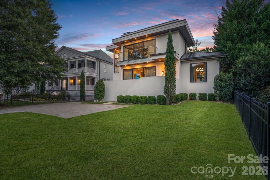 With over 7,200 square feet of heated living space, this stunning TRUE MODERN, Frank Smith–designed home offers a rare opportunity to live in a work of art overlooking the 7-acre lake at Freedom Park. Designed to embrace an outdoor lifestyle, this residence is pure luxury. The exterior features of this Modern Luxury include surround sound, a mounted TV under a covered back patio with remote-controlled shades, and a complete security system with 6 cameras plus remote controls for everything from indoor/outdoor fireplaces to exterior walls that disappear at the touch of a button. Throughout the home, you’ll find 10” wide engineered wood floors, sliding glass walls opening to a side-yard with outdoor living area, heated pool, putting green, and built-in grill & pizza oven. The custom Hans Krug kitchen features a concrete island, high-end Miele appliances, and a hidden scullery. The owner’s suite boasts a massive custom closet, spa-like bath with heated floors, a TV mirror, wet room, private laundry, and hand-selected marble finishes. Additional highlights include a full home theater, sauna, gated driveway, and 4-car garage.  Unique features set this home apart: a custom fish tank with a striking Charlotte skyline centerpiece, and a detached living quarters below the garage that has been transformed into the ultimate man cave, perfect for entertaining, watching the game, or escaping for a private retreat.