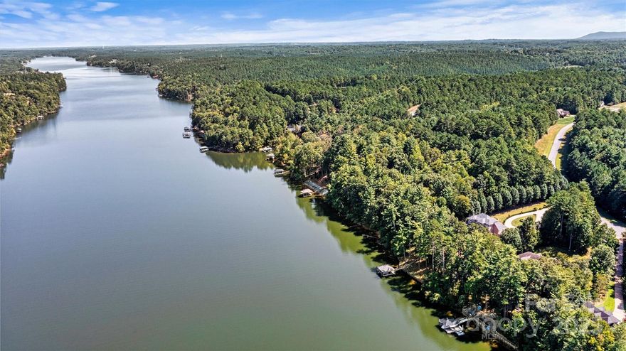 Discover the epitome of lakefront luxury in this stunning executive home in Harbor Ridge. Nestled on a private 1.46-acre lot, a stately circle drive and serene setting welcomes you to your private dock. Boasting 4,188 heated sq ft, this beauty offers 4 bedrooms and 3-1/2 baths designed for ultimate lake living. Natural light fills the home, creating an open and airy ambiance. The expansive top deck and lower patio w/grill area are an entertainer's delight. The main level highlights both formal and casual areas, while the kitchen features spacious granite with abundant storage. The cozy den invites relaxation, and the top deck offers stunning lake views. Upstairs, the expansive owner’s suite provides a spa-like retreat, along with 3 additional bedrooms and a full bath. The lower level enhances indoor & outdoor living with a den, kitchen, rec room, and full bath. A walk-in safe and expansive storage in the 3rd garage and workshop adds to the unique appeal. A Must See *New Roof*HVAC 2021*